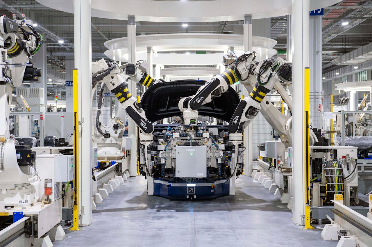 Mastering the First Impression: Your intriguing post title goes here High-tech robots assembling a car in a modern factory setting, showcasing automation.
